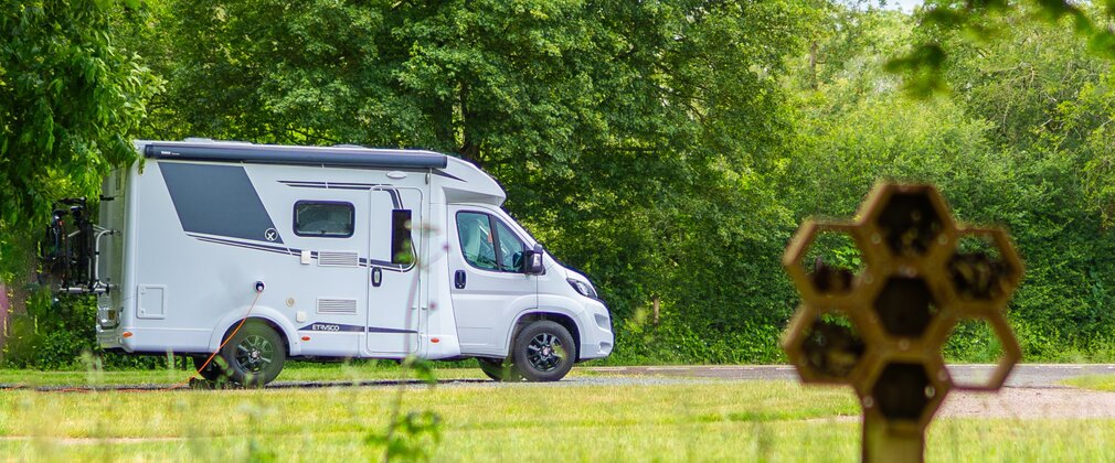 Motorhome at Fineshade Wood campsite with bug hotel in the foreground