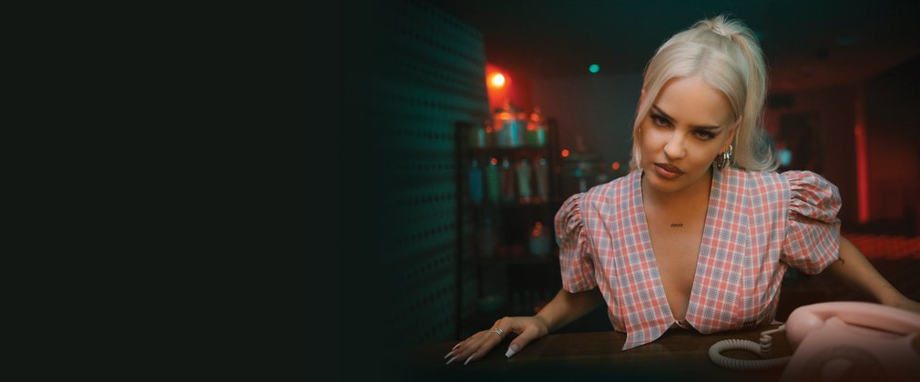 Pop star Anne Marie poses at a table