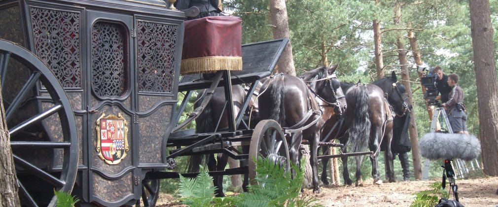 A still from the filming Elizabeth the Golden Age showing a carriage with driver being pulled by horses in the forest