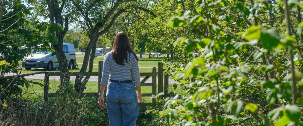 Woman walking towards Fineshade Wood campsite