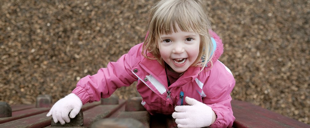 Little girl climbing in play area