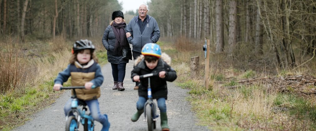 Family walking with boys on balance bikes