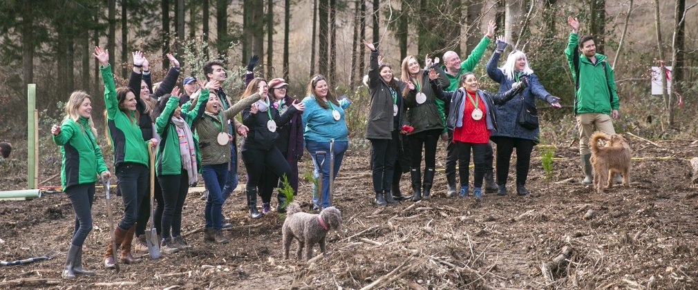 Group of people waving happily in a forest