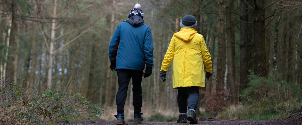 Couple walking on forest trail