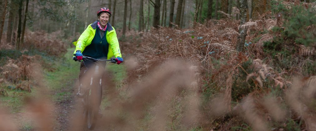 lady beginner mountain biker cycling in woods