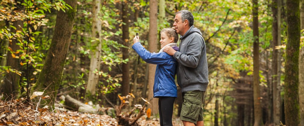 Family taking pictures in forest