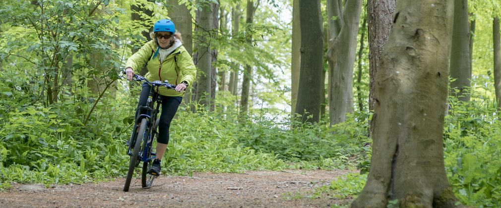 Woman on the easy cycle trail at Friston Forest