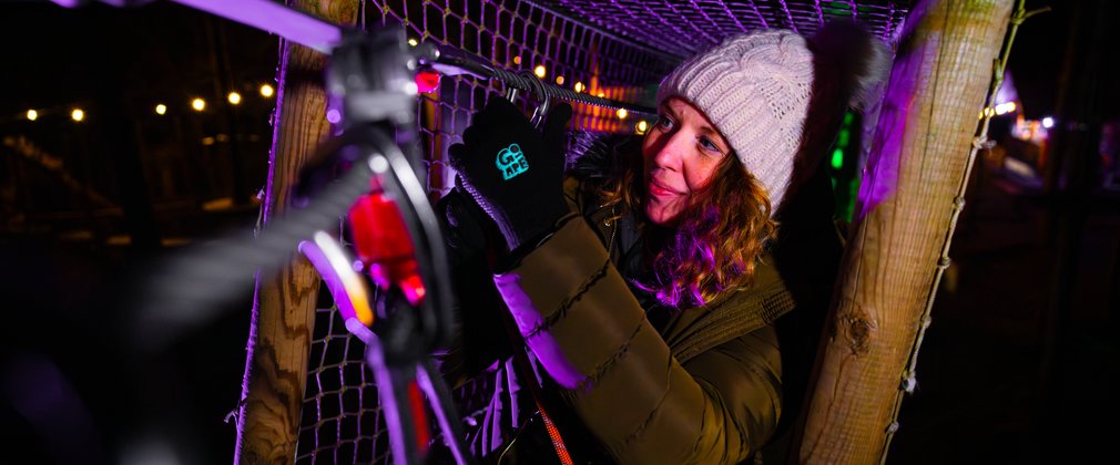 A women climbing on Go Ape after dark 