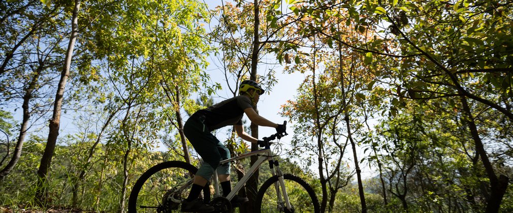 Woman mountain biking on spring forest trail