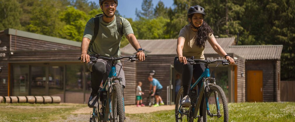 Two cyclists in front of the Activity Centre at Alice Holt Forest