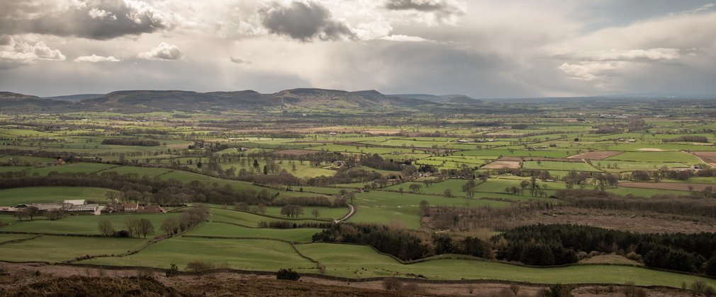 A view of open arable land with a range of hills on the skyline.