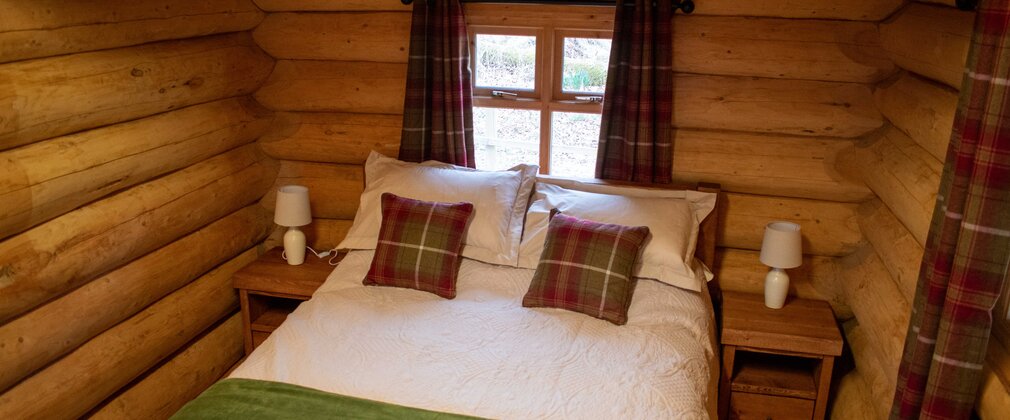 A double bed inside a log cabin