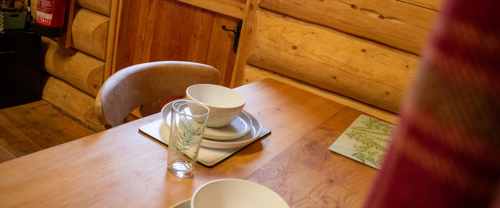 A small wooden dining table set for two