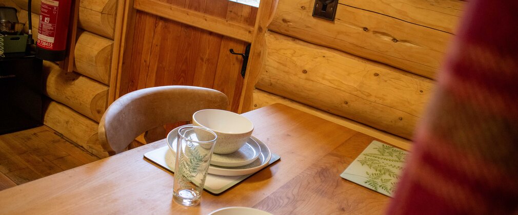 A small wooden dining table set for two