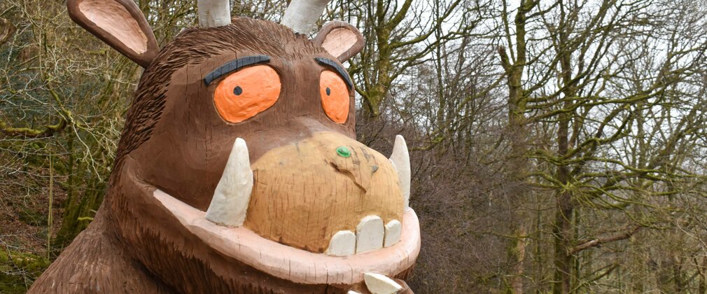 A Gruffalo sculpture standing in a forest