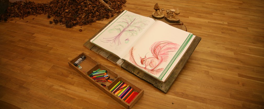 Drawing materials displayed on a wooden floor