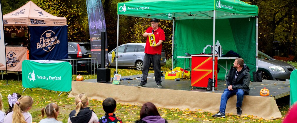 magician performs on stage at outdoor event
