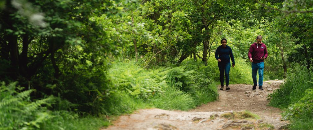 A couple walking along a forest trail