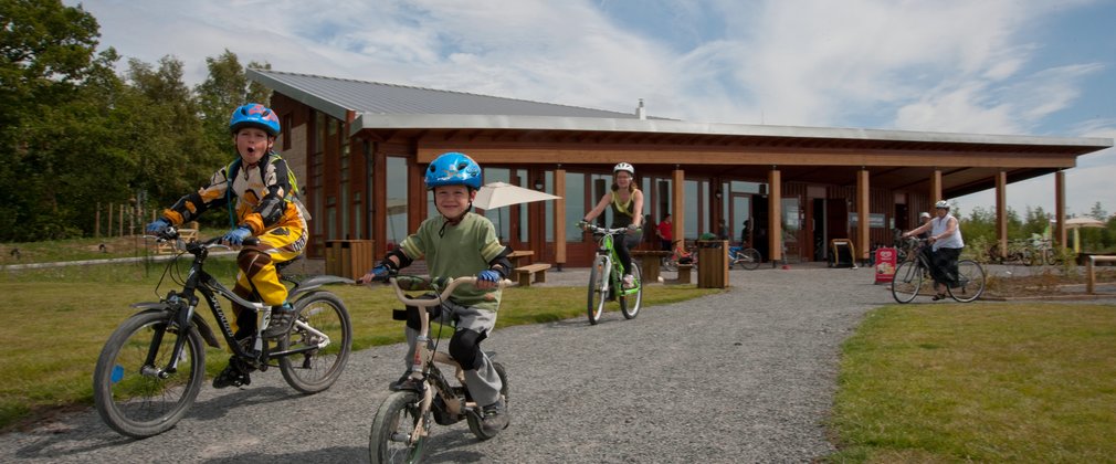 Family cycling away from the visitor centre