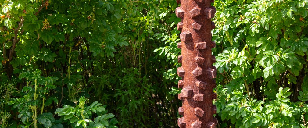 A patina iron sculpture based on the tread of a bike tyre