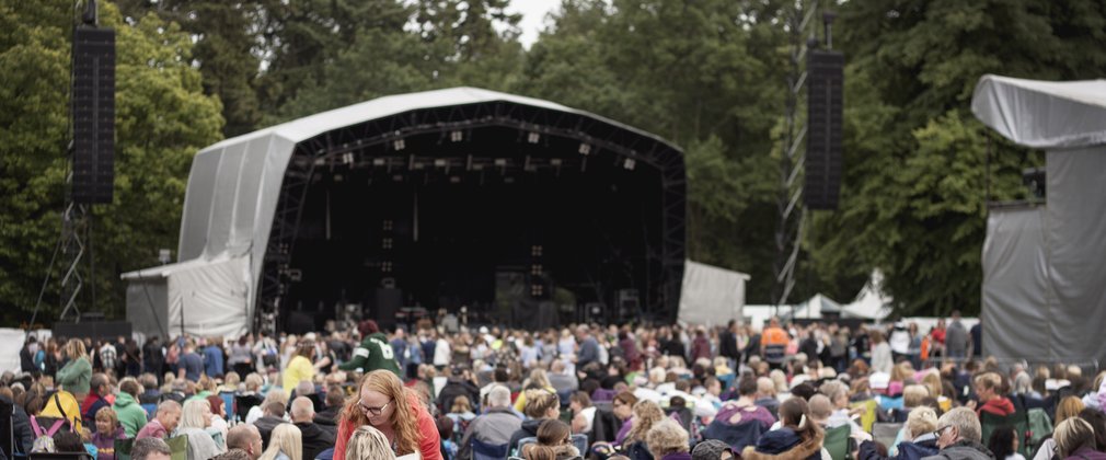 View of the stage from the back of the crowd at an outdoor concert