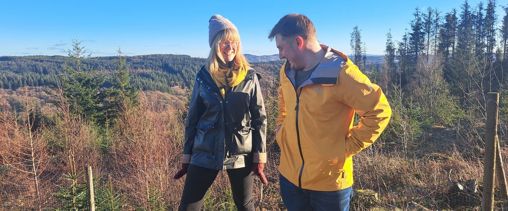 man and woman smiling in forest on a sunny winter day