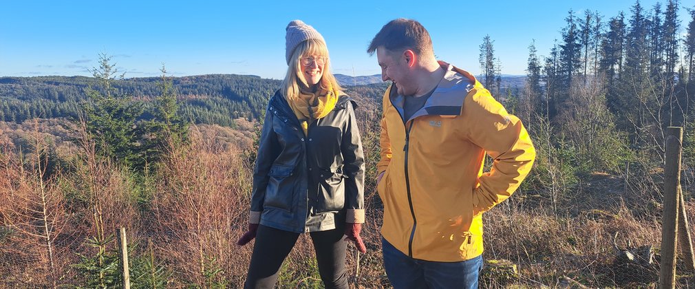 man and woman smiling in  forest on a sunny winter day