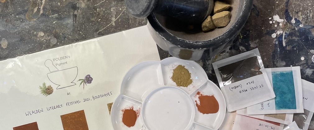 Paint pigments and colour charts with pestle and mortar