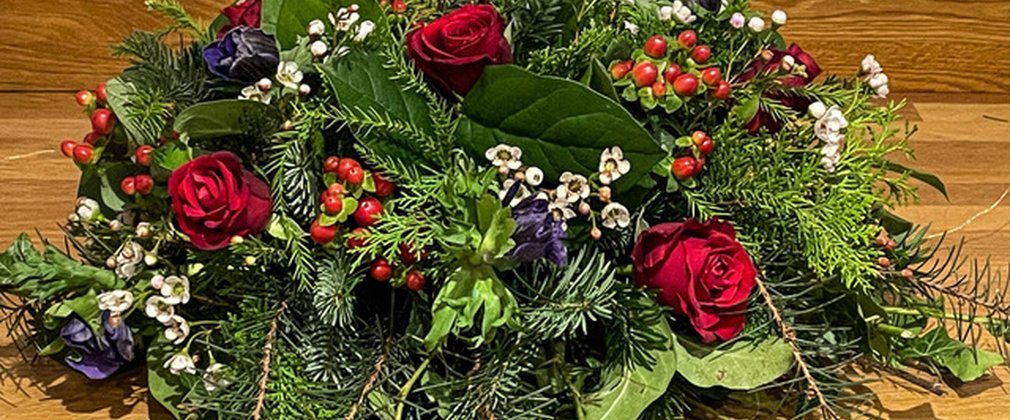 A Christmas floral arrangement on a wooden table