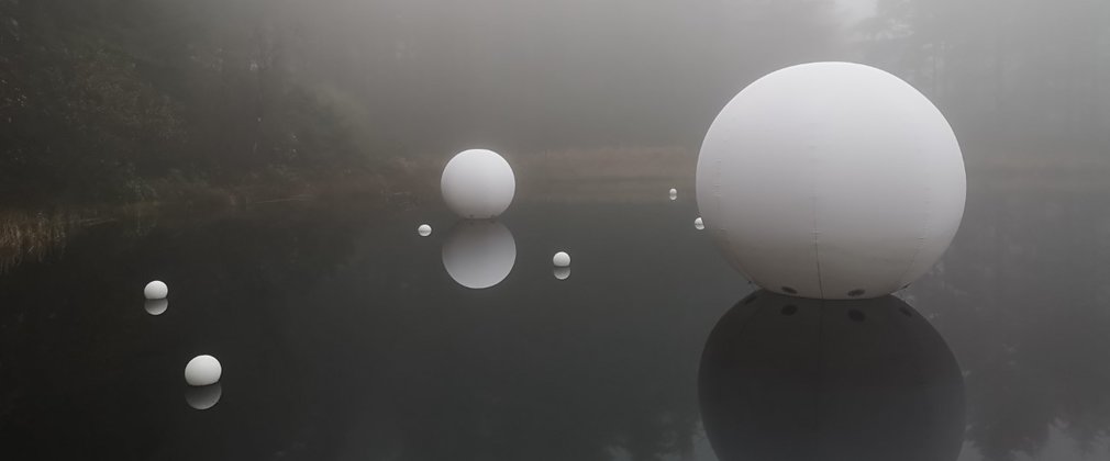 Spherical sculpture on water in mist