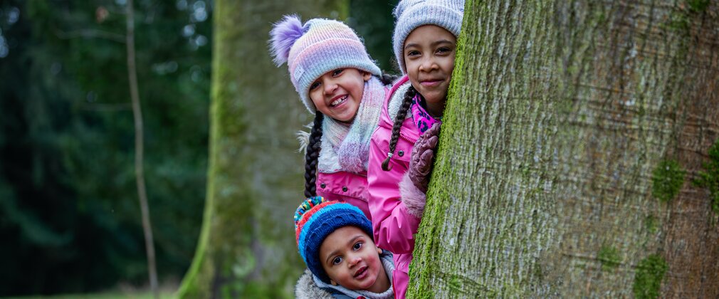 Family wrapped around tree trunk