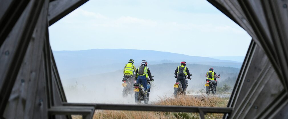 A group of motorcyclists driving away into the landscape