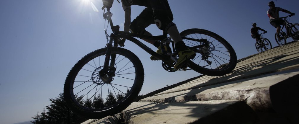 Mountain biker riding over timber flyover at Kielder