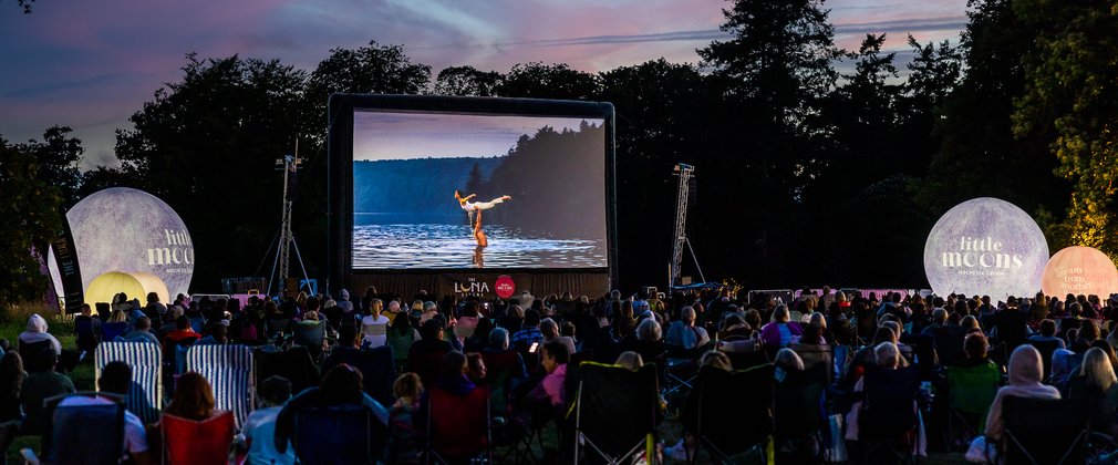 Crowd watching Luna Cinema in the forest at night