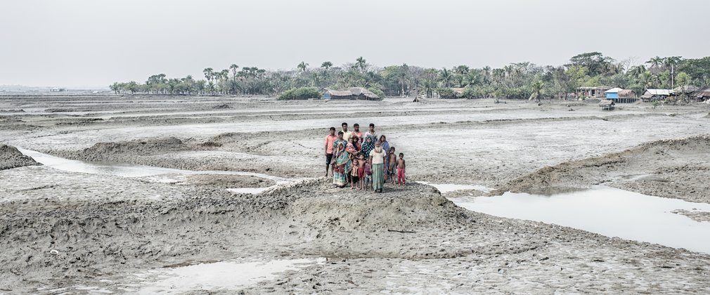 Small group of people in Bangladesh standing on flooded land