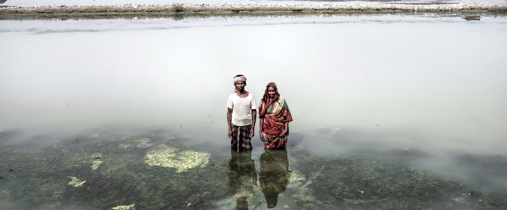 Two people in Bangladesh standing in flooded land