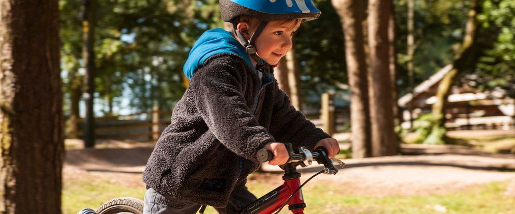 Child riding a balance bike in the forest
