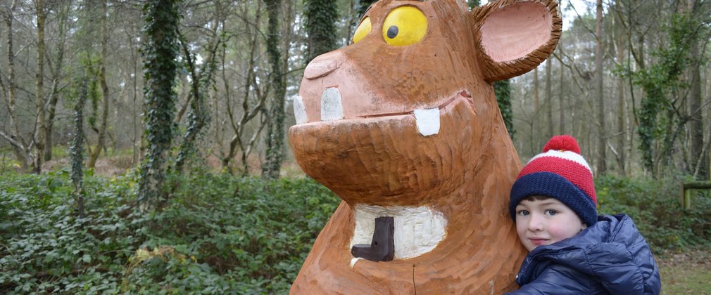 Child hugging Gruffalo sculpture