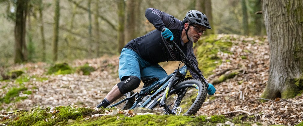 Man mountain biking through a forest