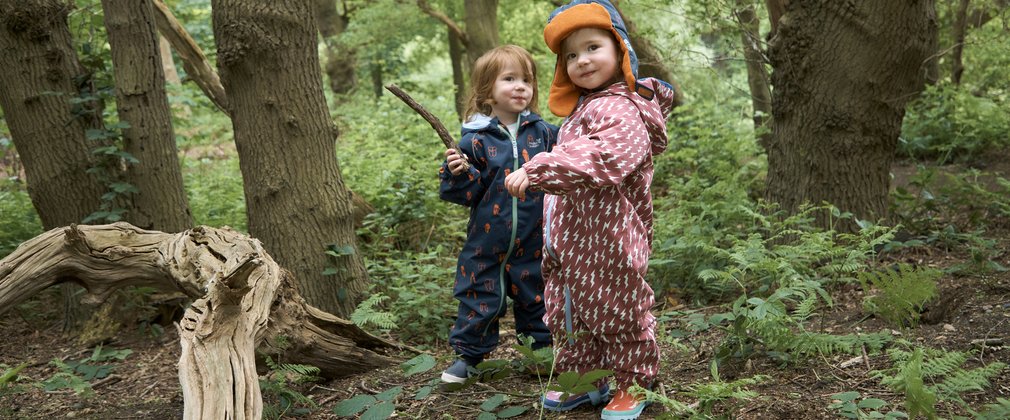2 children in waterproofs in the forest