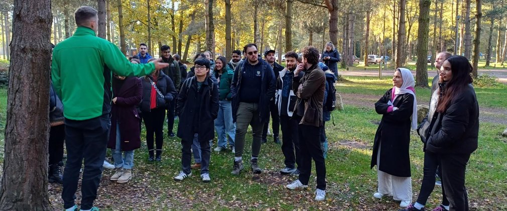 A member of Forestry England staff talks to a group of people in the forest
