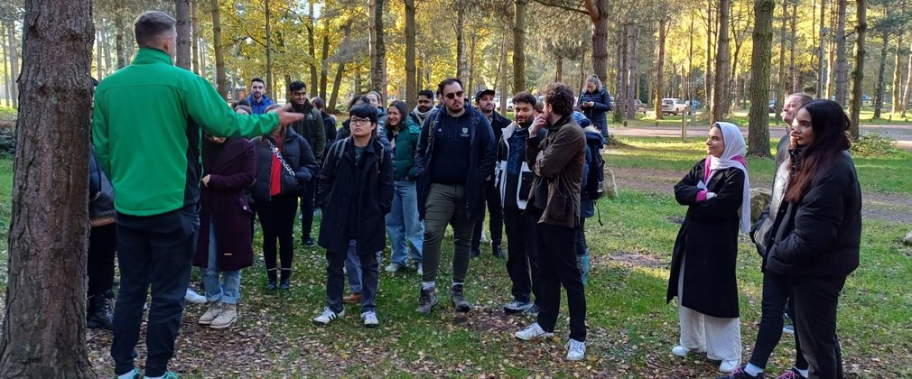 A member of Forestry England staff talks to a group of people in the forest