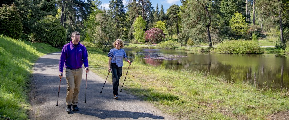 Two people Nordic Walking by a lake