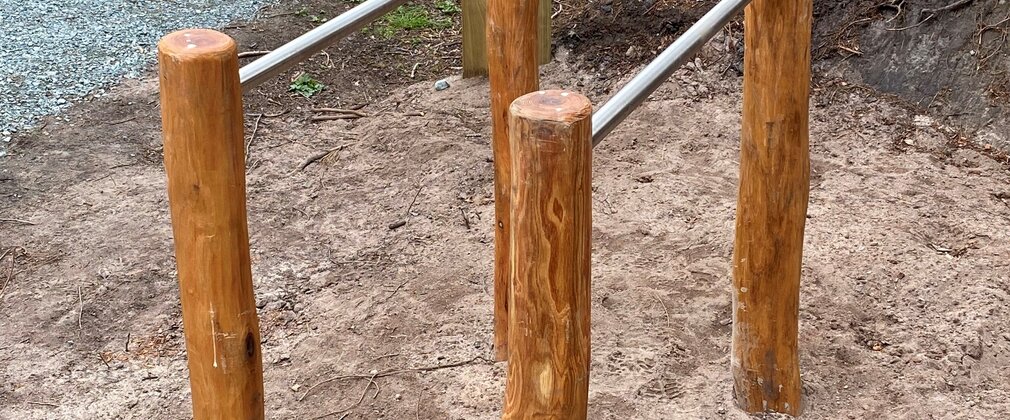 Some parallel bars with instructional signage in the background