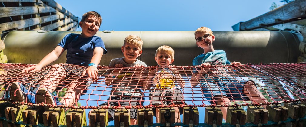 Children on play area bridge looking down 