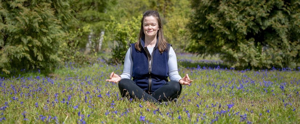 Person sitting on the grass amongst spring flowers