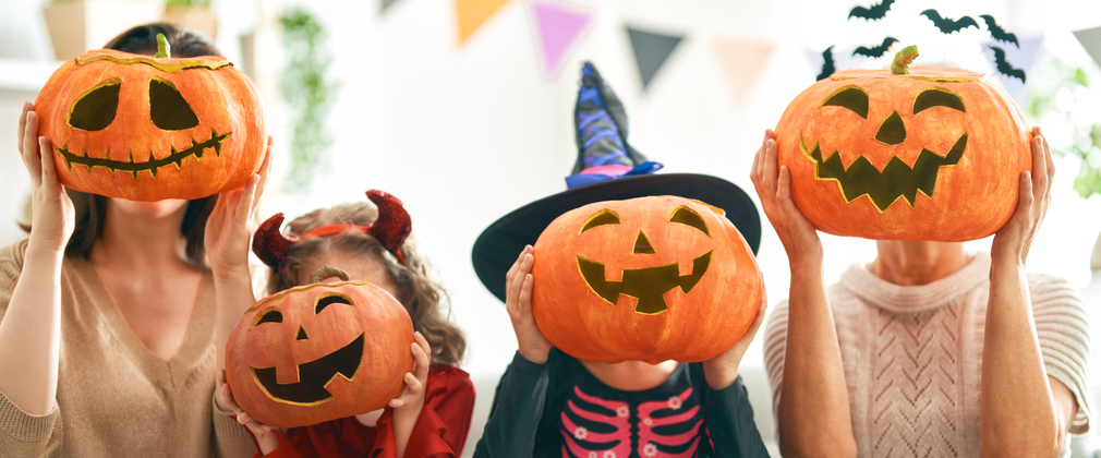 Family holding up carved pumpkins