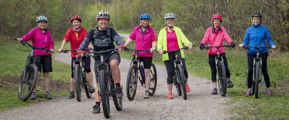 Group of cyclists on forest track smiling