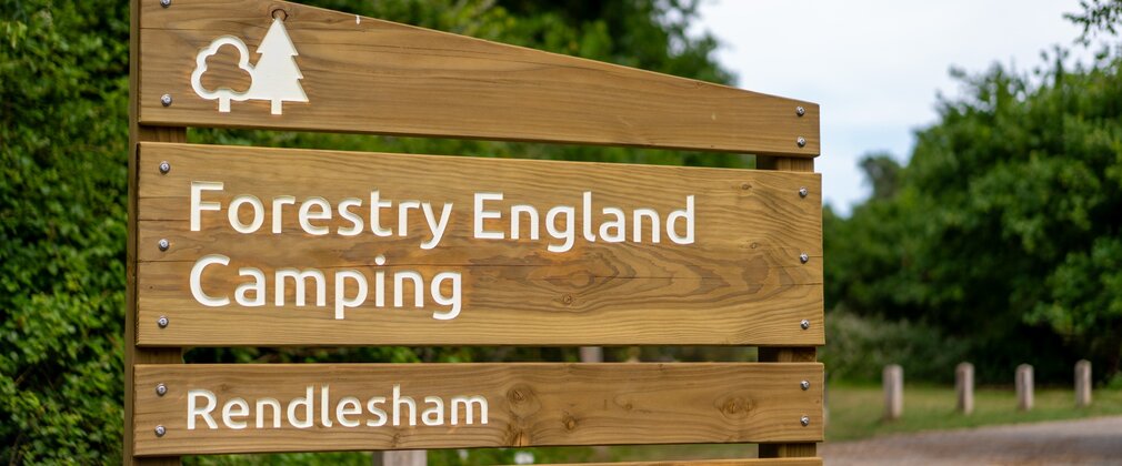 Wooden signage at entrance of Forestry England Camping at Rendlesham
