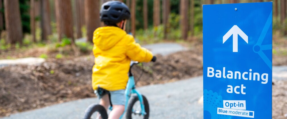 boy rides balance bike at high lodge pedal and play